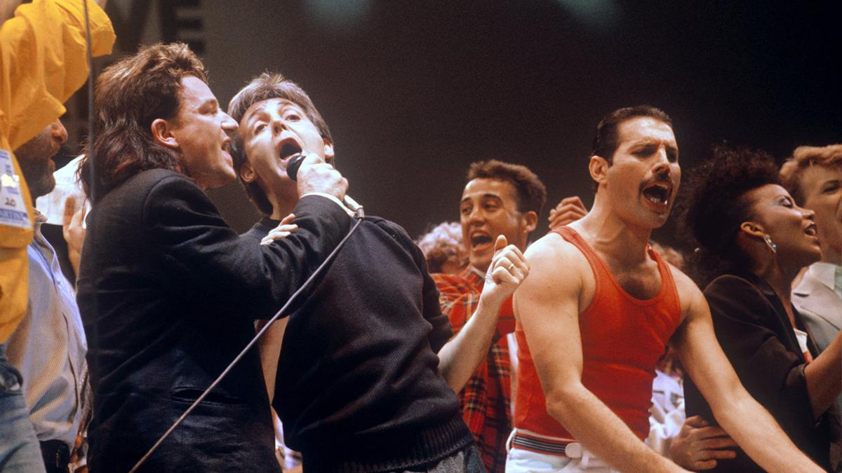 Bono, Paul McCartney y Freddie Mercury cantando "¿Saben que es Navidad?".