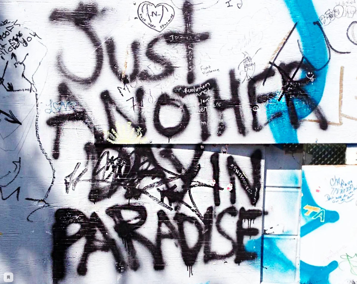 Grafiti con el título de la canción "Otro día en el paraíso"