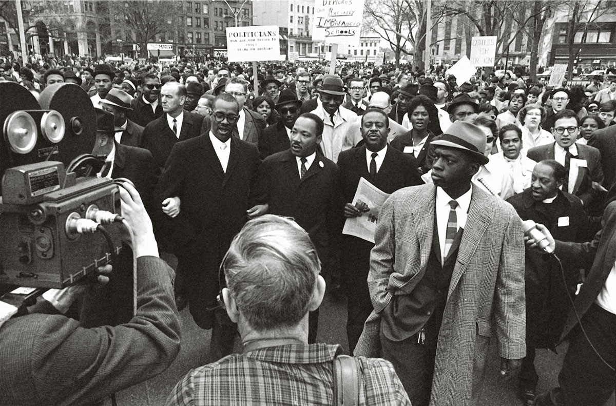 One year before the murder. April 23, 1965. Martin Luther King Jr. walks down Charles Street with Ralph Abernathy (right) and Reverend Virgil Wood, head of the Boston chapter of the Southern Christian Leadership Conference.