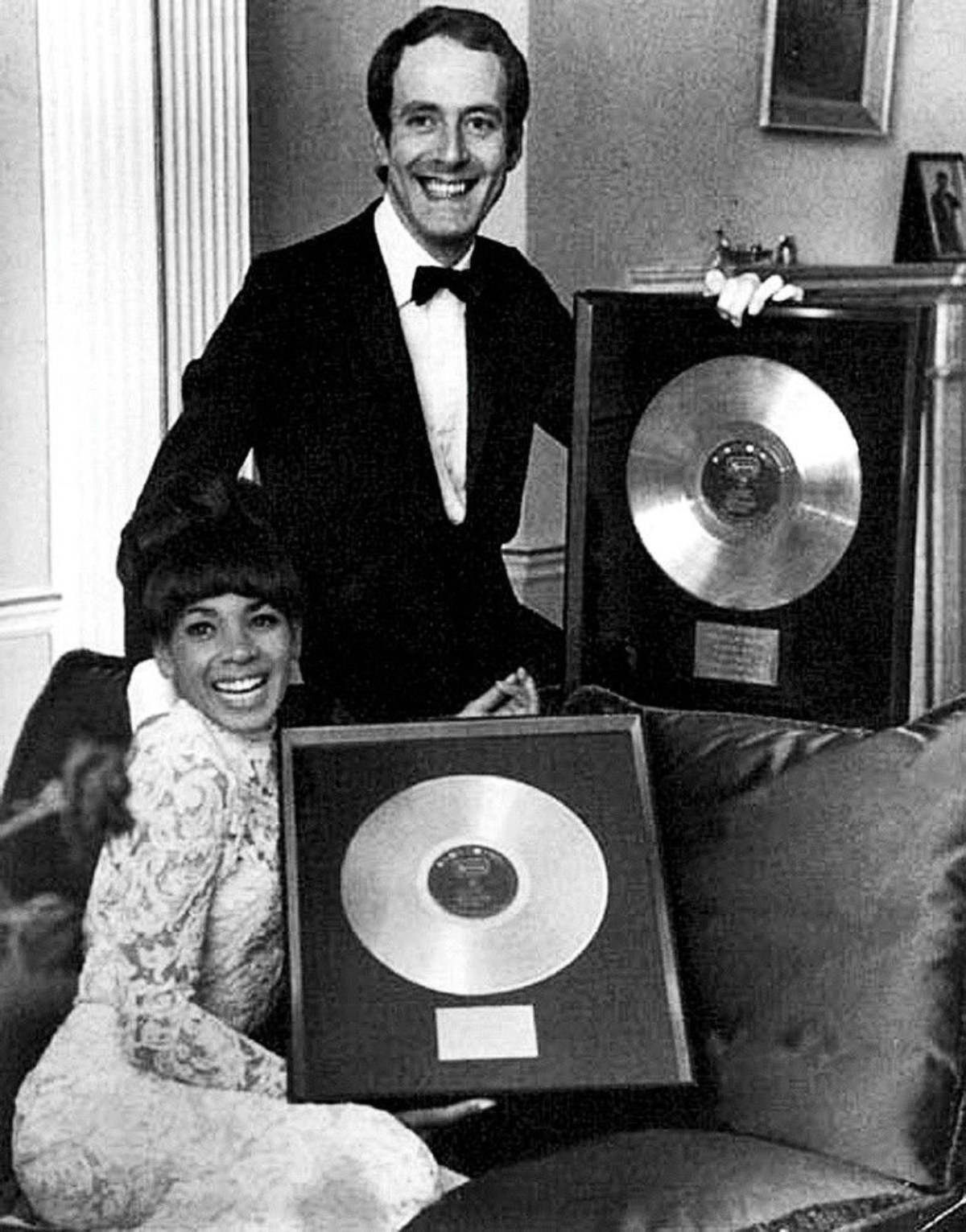 Джон Барри и Ширли Бэсси позируют со своими золотыми дисками для Goldfinger...