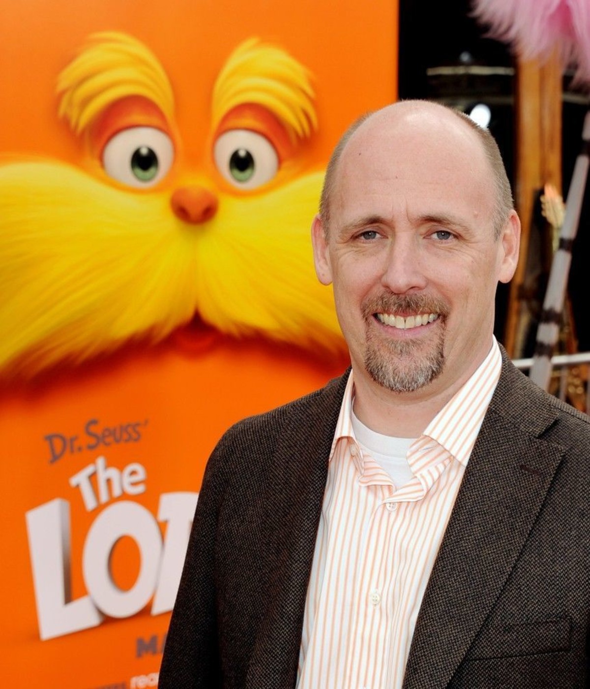 Chris Renaud in front of a poster for the animated film The Lorax.