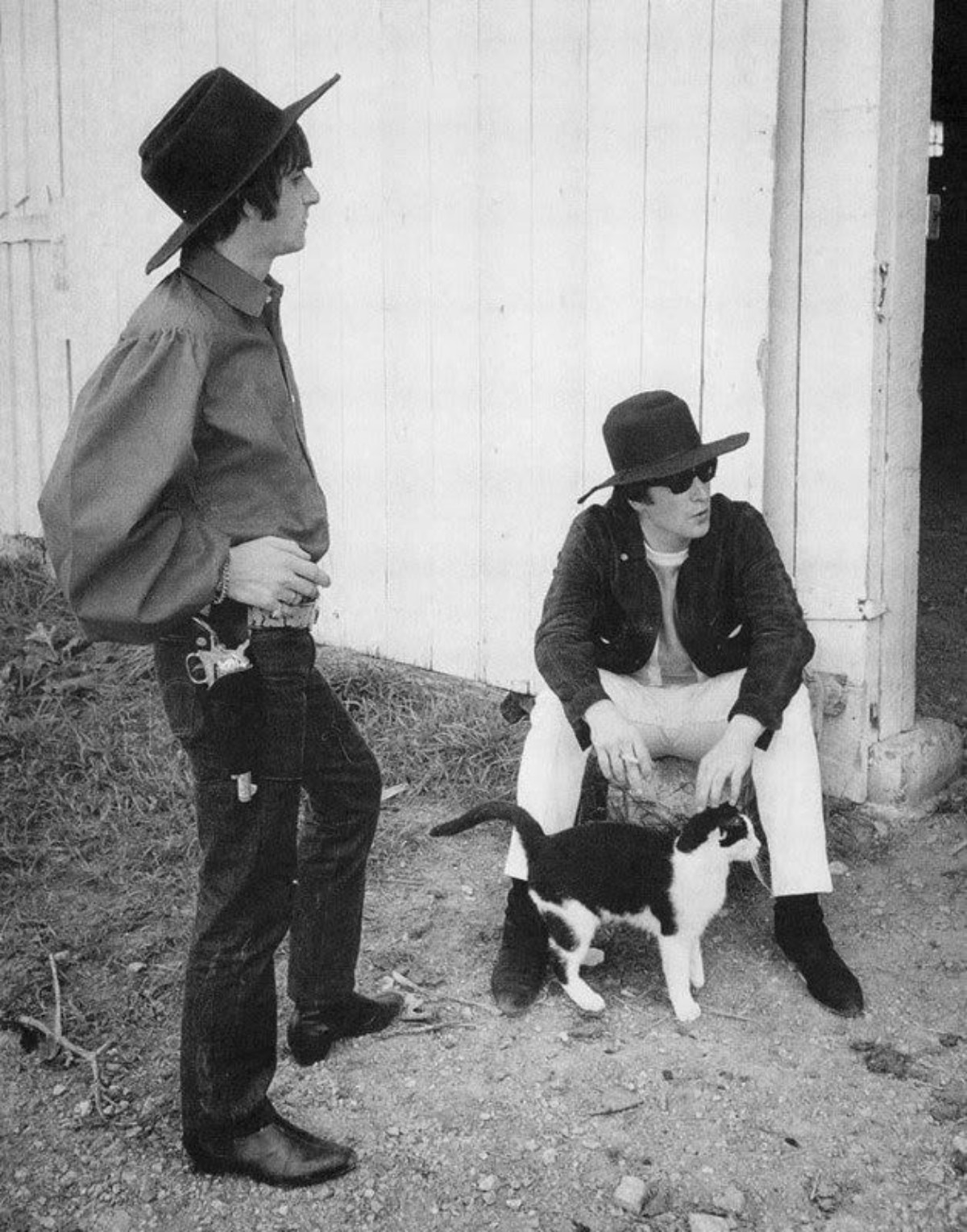 John Lennon se repose avec le chat à ses côtés.