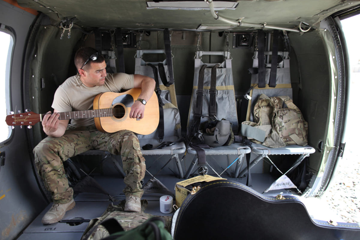Un soldat des forces spéciales joue de la guitare
